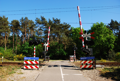 900102 Gezicht op een spoorwegovergang in de spoorlijn tussen Den Dolder en Soest Zuid.